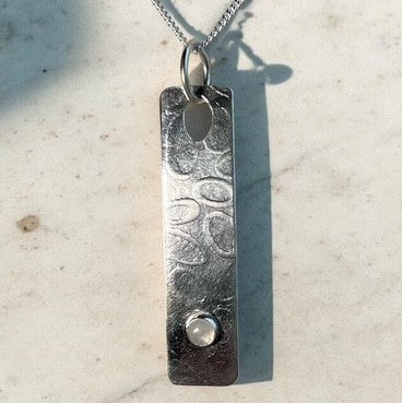 Pendant with rippled stone texture and labradorite gemstone