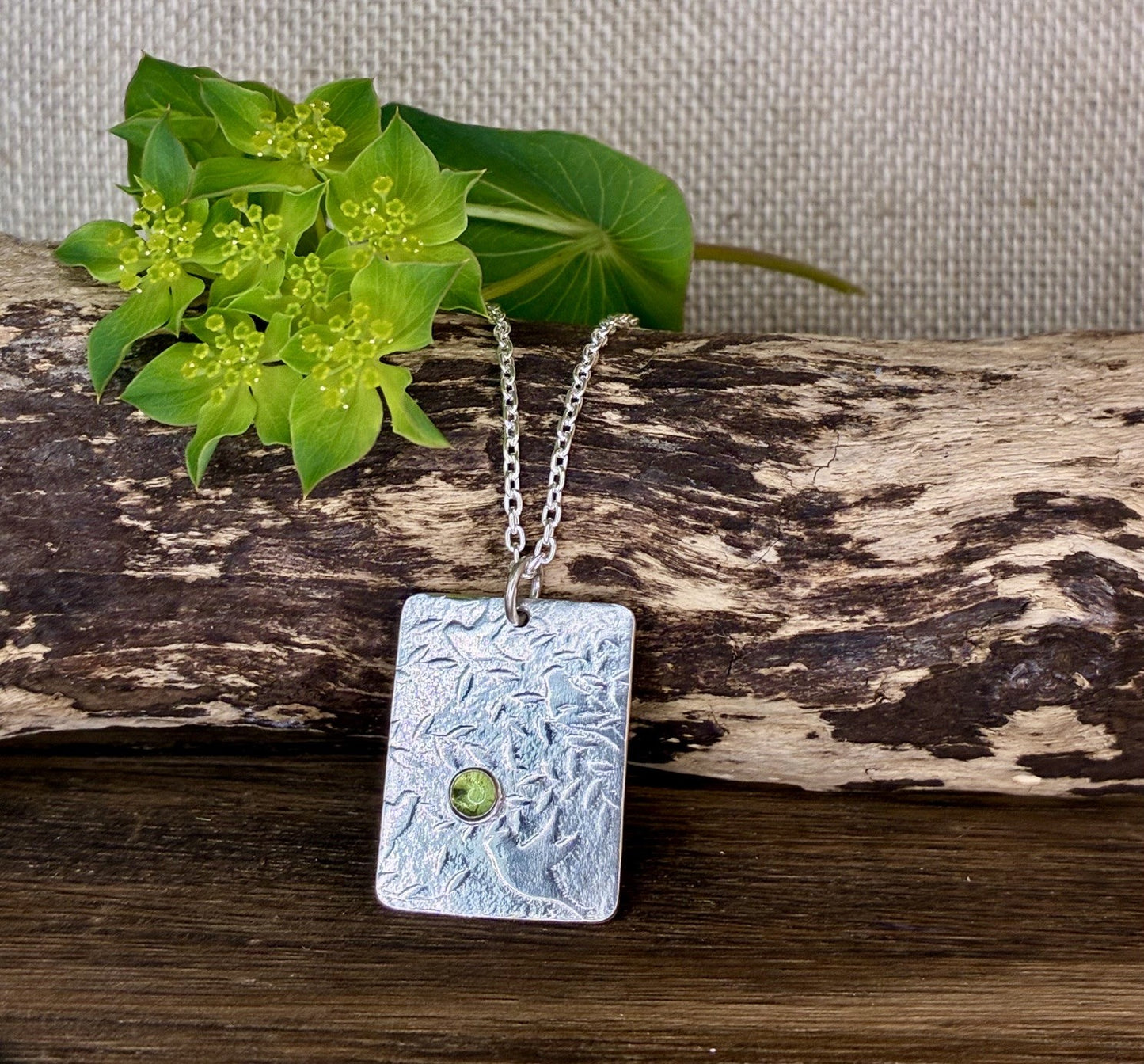 Pendant with bird and leaf texture and peridot gemstone