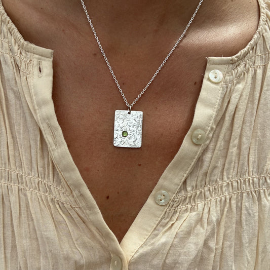 Pendant with bird and leaf texture and peridot gemstone